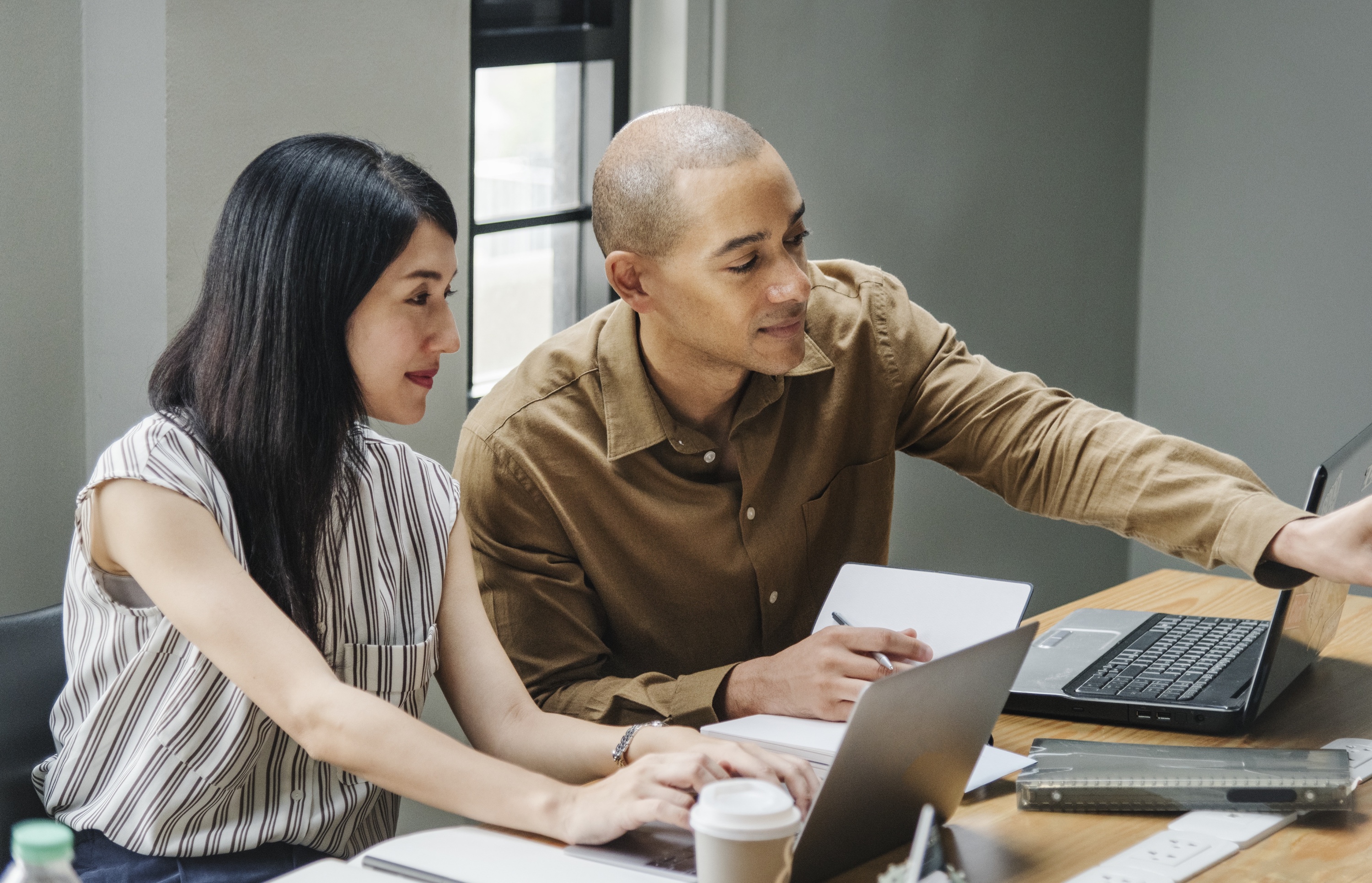 Man Pointing To A Computer Screen While A Woman Watches - Global Solution Services (GSS)