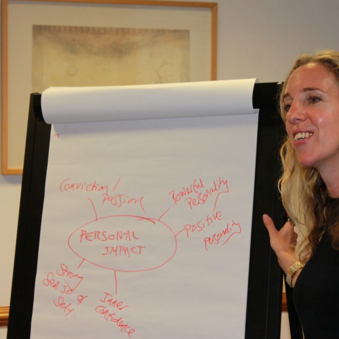 Smiling woman next to a whiteboard